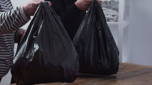 feet of refugees or homeless people in dirty cheap shoes. A faceless woman with large bags in her hands