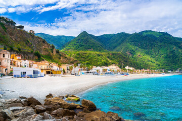 View of the famous beach Spiaggia Di Scilla with crystal clear turquoise water. Beautiful seaside village with old colorful houses in Scilla, Italy.