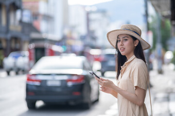 She is looking at the phone while a car is driving by