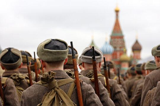 Russian soldiers in Soviet military uniform of World War II on Red square standing on St Basil Cathedral background