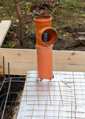 A pipe is sitting on a concrete slab with a piece of wood on top of it