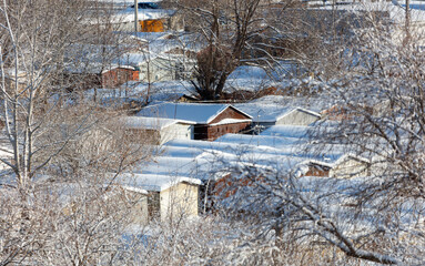 A snowy landscape with a row of houses and a shed