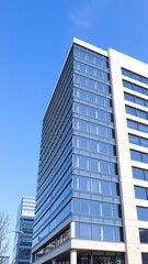 Obraz premium Modern office building against a clear blue sky backdrop, corporate