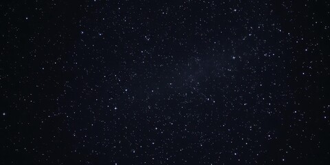 Fototapeta premium Night sky filled with sparkling stars on a dark black background, glittering