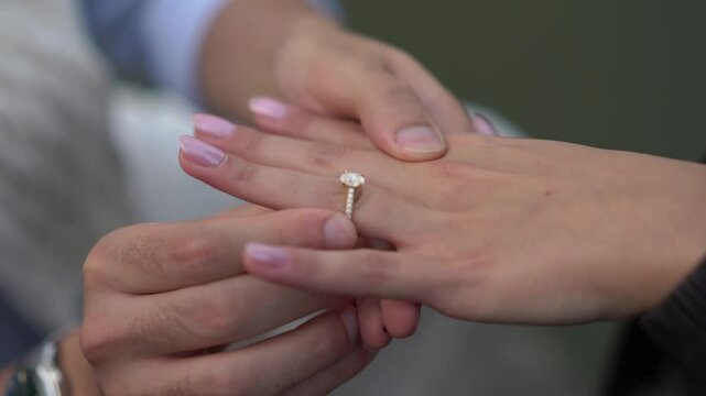 An enchanting romantic engagement moment features a beautiful diamond ring displayed on elegant, captivating hands