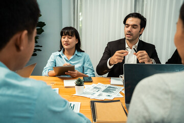 Diverse group of business analyst team analyzing financial data report paper on office table. Chart and graph dashboard by business intelligence analysis for strategic marketing planning Habiliment