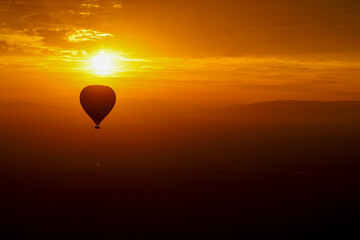 Hot air balloon silhouette at sunrise over African savannah	