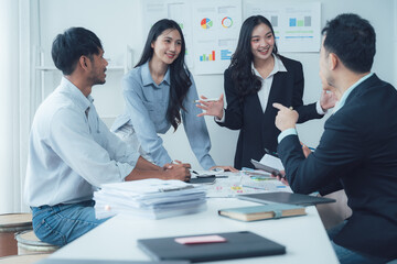 Business Meeting: A diverse team of professionals collaborates and discusses ideas around a table in a modern office setting.