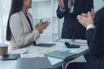 Business Meeting Applause: A group of business professionals, dressed in suits, applaud a colleague during a meeting. The image portrays a sense of camaraderie and success in the workplace.  