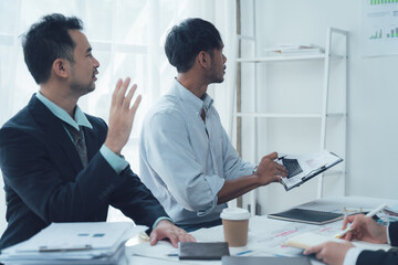 Strategic Business Discussion: Two focused businessmen engage in a serious discussion, reviewing documents and charts during a productive meeting.  The image conveys professionalism and collaboration.