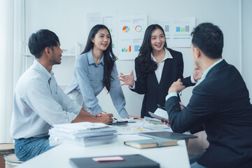 Business Meeting: A diverse team of professionals engages in a lively discussion around a table, surrounded by charts and reports, showcasing collaboration and strategic thinking. 