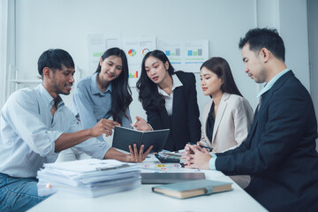 Teamwork Makes the Dream Work: A diverse group of business professionals collaborates around a table, engaged in a serious discussion over documents and charts.