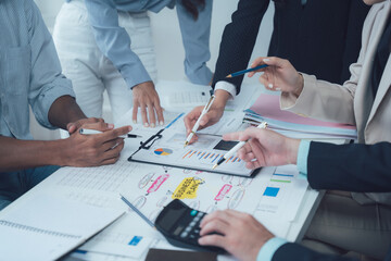 Teamwork Makes the Dream Work: A diverse group of business professionals collaborates around a...