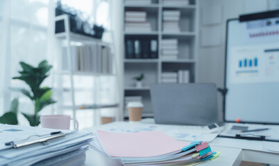 Organized Workspace: Productivity and efficiency in a modern office setting.  A clean desk with organized paperwork, laptop, and office supplies.  Sunlight streams through the window.