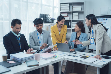 Collaborative Business Meeting: Diverse Team of Professionals Brainstorming and Discussing Documents and Laptop in Modern Office