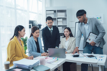 Business Team Meeting: A diverse group of professionals engaged in a collaborative discussion, examining data and strategizing for success, fostering a dynamic and productive work environment. 