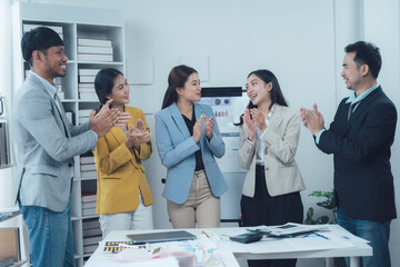 Business Team Applauds Success: A group of diverse business professionals express their appreciation and enthusiasm, applauding a colleague in a modern office setting.