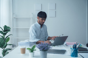 Focused Professional: Man Working on Laptop in Modern Office 