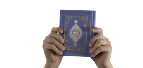 Believer's hands holding the Quran. Book with Arabic title All Quran. Muslim religious scripture. Isolated background.