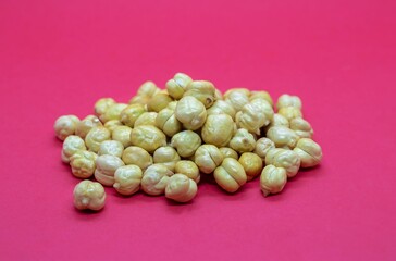 Roasted Chickpea or Garbanzo Bean Heap Isolated on Red Background with Copy Space, Also Known as Bengal Gram or Egyptian Pea