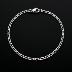 Sterling silver flat cable chain lightweight and flexible on plain black dark background