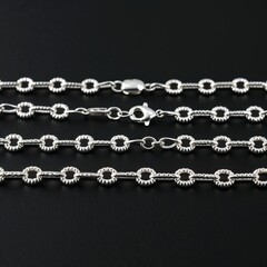 Sterling silver popcorn chain playful and textured on plain black dark background