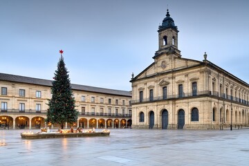 Obraz premium Plaza principal con un gran árbol de Navidad frente a un edificio histórico en invierno. 