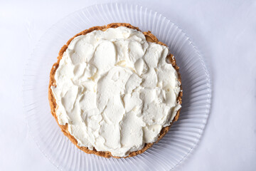 Banoffee banana pie with caramel sauce and cheese cream on the white background. Traditional...
