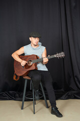 Obraz premium Musician playing an acoustic guitar in a casual studio