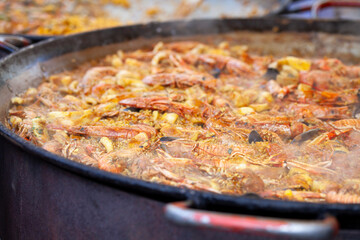 .Authentic seafood paella, made with fresh shrimp, mussels, squid, and tender fish, all simmered with saffron, garlic, bell peppers, tomatoes, and a touch of paprika.