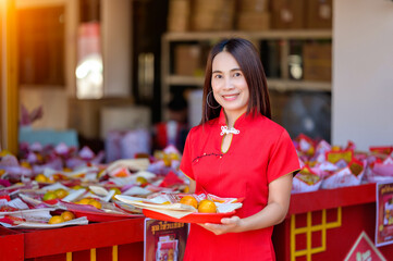 Woman in Red Dress Holding Fruit Tray at Festival