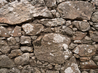 Old, rough, natural stone wall background texture.