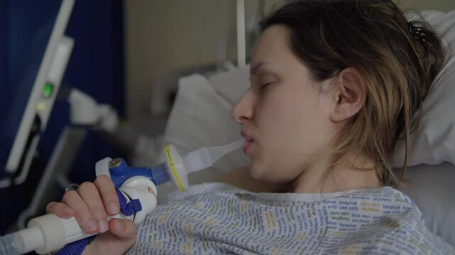 Woman inhaling gas to help with the pain of birthing contractions as she prepares to bring a newborn into the world