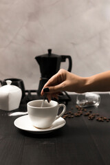 
Black coffee is poured into a cup, on a black background. pour milk into coffee