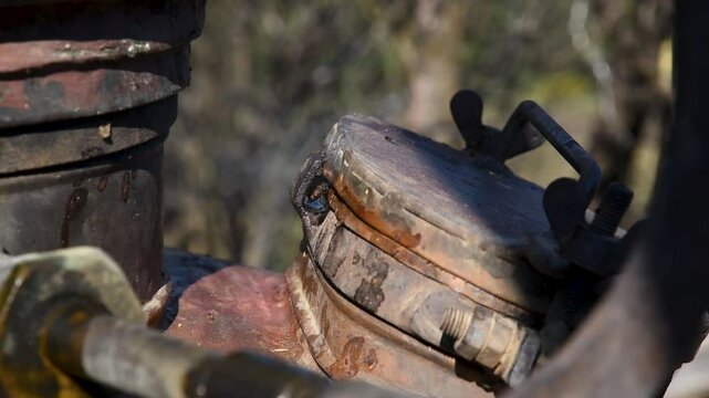 Hot steam escapes from under boilers lid of brandy cauldron close up, poor seal