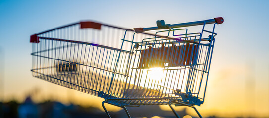 Empty shopping cart in water in sunset light.