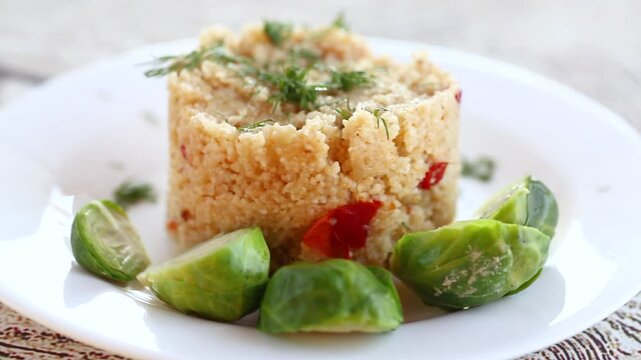 homemade cooked bulgur with Brussel sprouts in a plate, on a wooden table