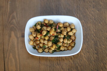 A close-up of a delicious and healthy Turkish appetizer, featuring roasted chickpeas with herbs and spices, served in a white bowl