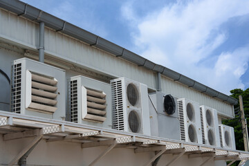 Air compressor or air condenser unit located on support outside building to heat released...