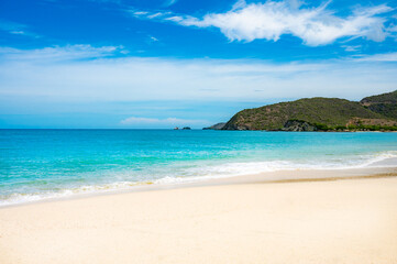 beach with a rocky shoreline and a small hut in the distance