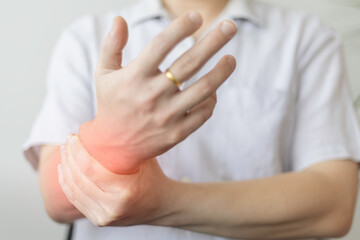 Closeup of man touching his wrist, suferring from arthritis disease.