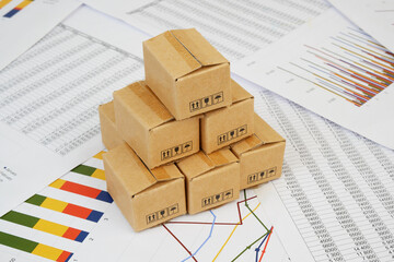 Managing shipment and cargo concept. Shipping carton boxes on financial documents.