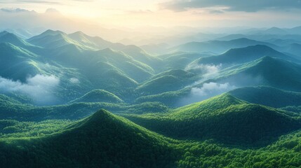 A panoramic view of a lush green mountain range at sunset with fog rolling through the valleys.