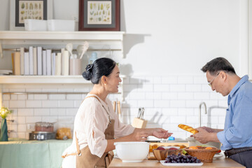 A woman prepares fresh vegetables in a cozy kitchen, while a man assists in the background. The scene emphasizes a warm and healthy lifestyle with a focus on fresh produce and home cooking.
