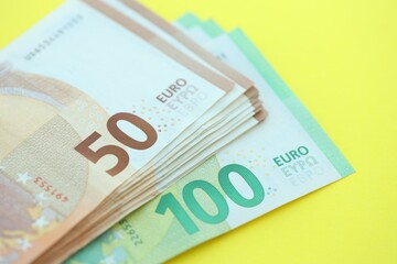 Big amount of one hundred and fifty euro money bills on yellow background