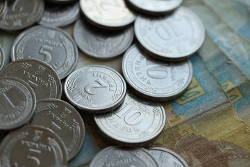 Ukraine money coins lying on mixed hryvnia banknotes, background.