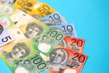 Few modern Australian dollar bills in different denominations lies on blue background