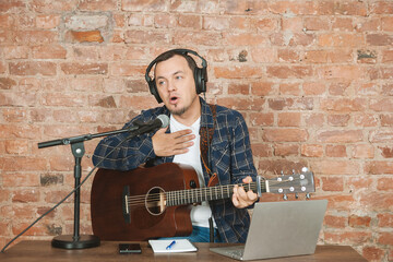 Musician singing and playing guitar with microphone and headphones