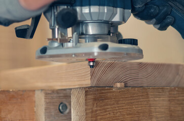 Handheld router tool shaping and smoothing wood edges, focus on skilled carpentry work