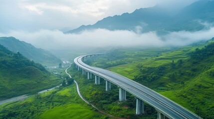 Obraz premium A winding highway through lush green hills and misty mountains, showcasing natural beauty.